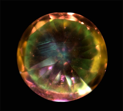 Fig. 3 - Under intense UV excitation the diamond shows an orange sector as well as a general green and blue fluorescence with a notable distribution in "graining", oriented along octahedral faces.